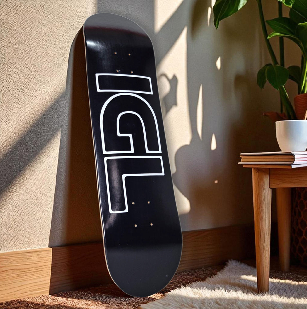 tabla de skate negra igl apoyada en la pared