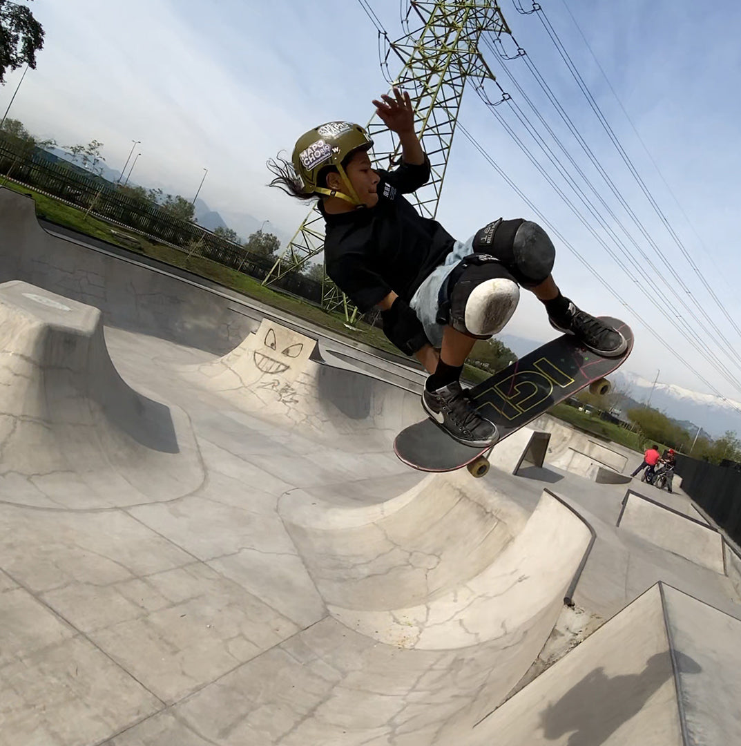 Skater sobre tabla de skate igl en skatepark de concreto