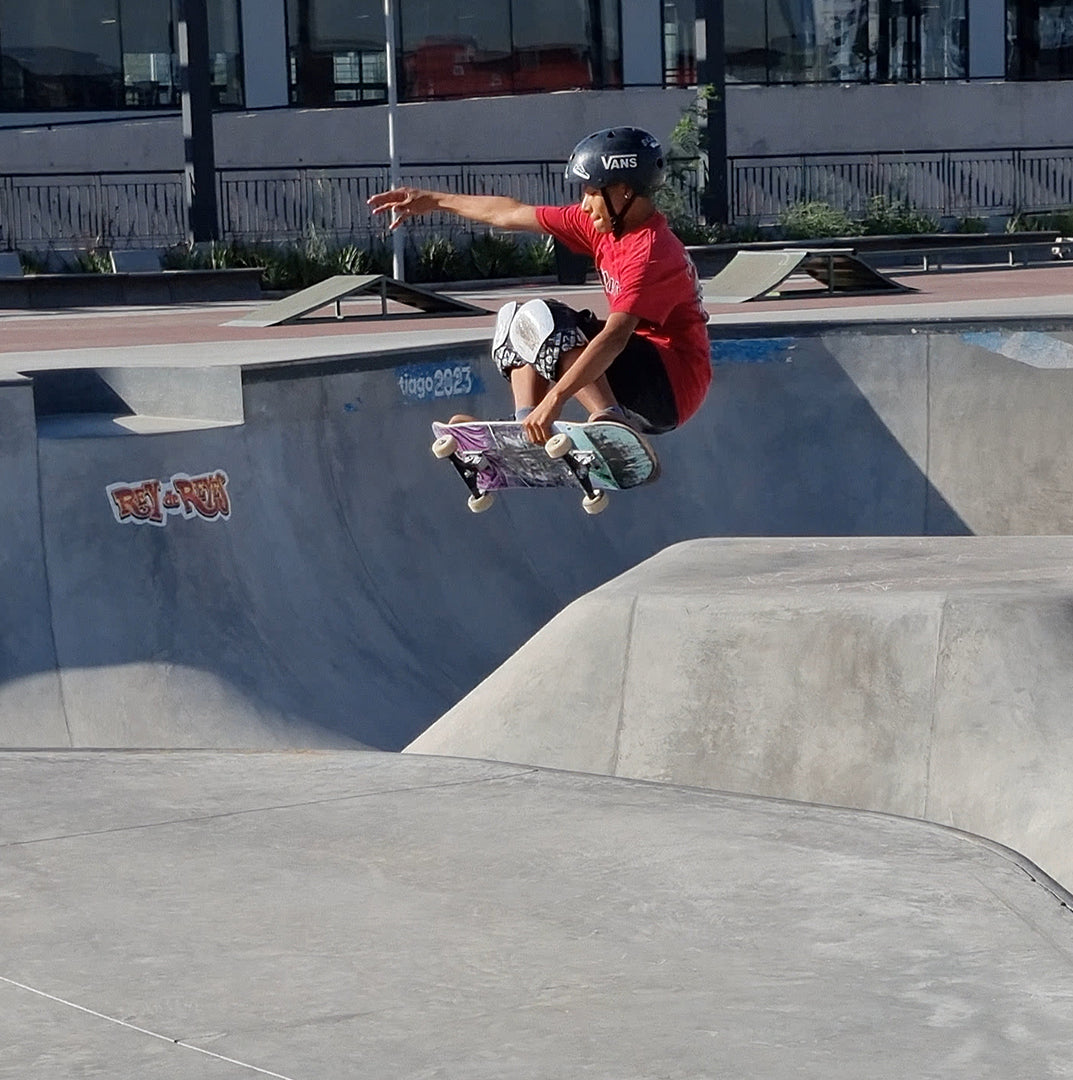 Skater con su tabla de skate igl modelo trip saltando en el bowl
