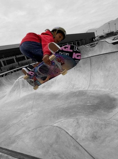 entrenando skate niño saltando en el skatepark