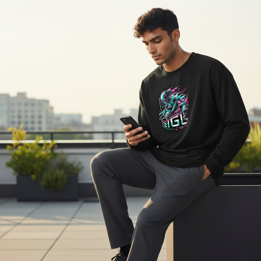 Viendo el celular sentado con polera negra alien igl