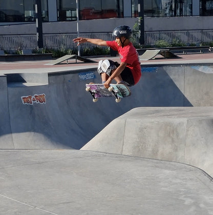 Skater con su tabla de skate igl modelo trip saltando en el bowl